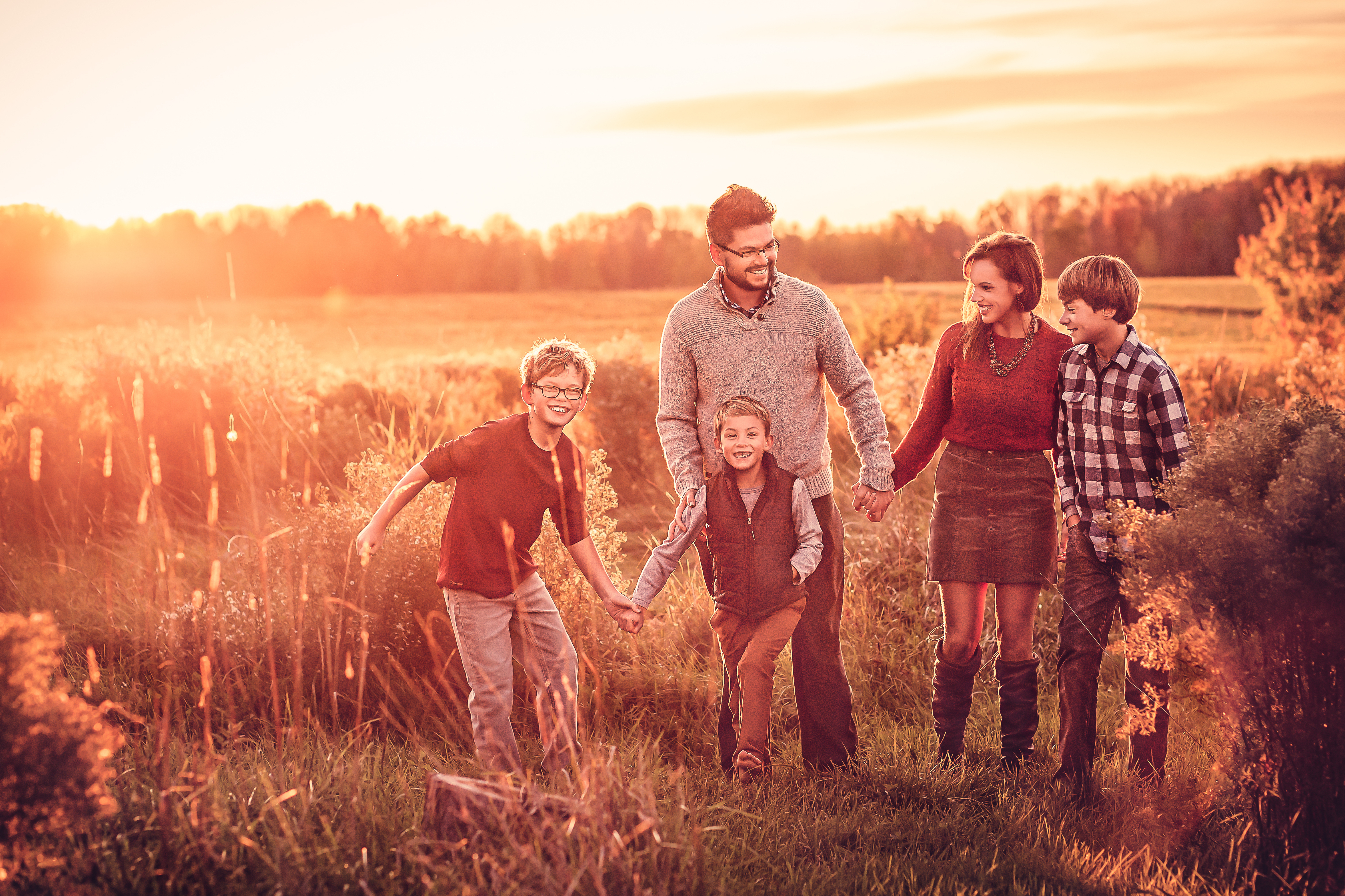 A beautiful family holding hands while walking during golden hour for their Family Photoshoot near Wausau, Wisconsin.